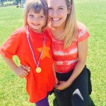Ellie is posing for a picture with the medal