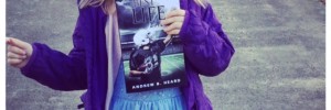Ellie in blue color frock holding the best life book in her hand