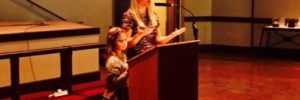 Bailey with her daughter Ellie giving speech at an event